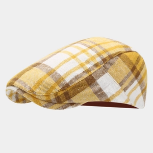 Gros plan sur le motif à carreaux jaune et la texture du tissu de cette casquette plate