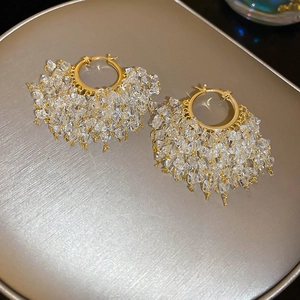 Macro detail of 18k gold plated hoop earrings with shimmering clear cubic zirconia crystals