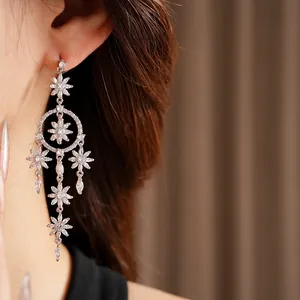 Silver flower tassel drop earrings with sparkling zircon crystals worn by a model