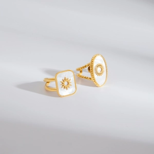 Golden titanium steel rings with sun motif on white shell inlays in square and oval shapes
