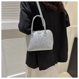 Detail of light gray crocodile embossed felt shell bag with metallic gold zippers