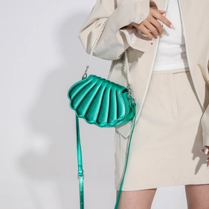 Glänzende grüne Handtasche in Muschelform mit Perlengriff und Metalloptik