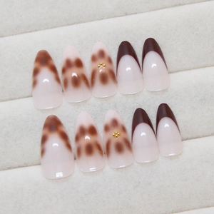 Brown leopard print and pearl press-on nails in long oval shape on velvet tray