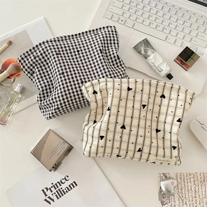 Vue détaillée du sac à cosmétiques à damier avec motif cœur et texture en tissu