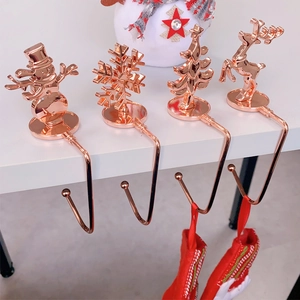 Set of four rose gold Christmas hooks featuring snowman, snowflake, tree, and reindeer motifs
