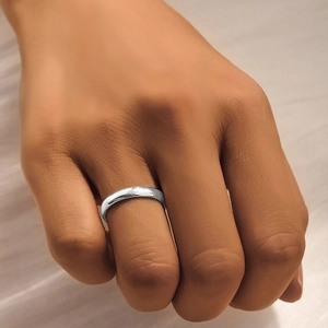 Close-up of a minimalist silver opal ring with star and moon accents on a finger