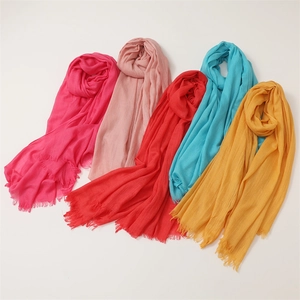 Close-up of cotton linen scarves in various colors featuring soft tassels and texture