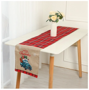Detail of red and black plaid table runner with blue truck embroidery and merry christmas text