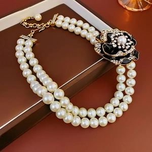 Detail of vintage French double-row pearl necklace with rhinestone flower in a gift box