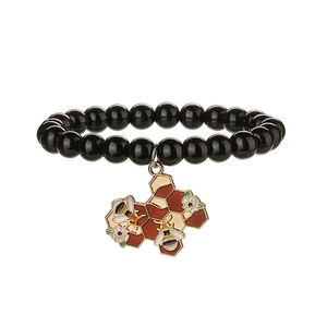 Bracelet en pierre naturelle noire avec pendentif abeille et alvéole en émail doré