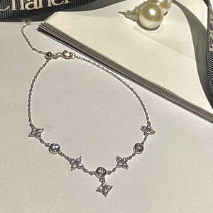 Close-up of 925 sterling silver bracelet featuring clover charms and zircon stones