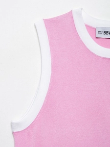 Gros plan d'un débardeur en maille rose avec col rond contrasté blanc et étiquette logo