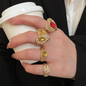 Detail of four vintage gold resin heart rings with lava texture and colored gemstones