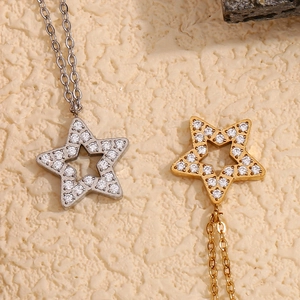 Detail of gold and silver hollow star pendants with cubic zirconia on fine O-chains
