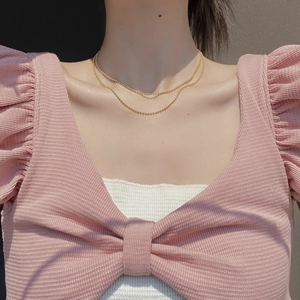 Minimalist S925 sterling silver layered gold bead necklace on model with pink top