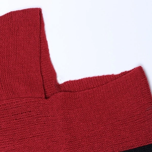 Close-up of the textured red knit neckline with detailed craftsmanship on a poncho