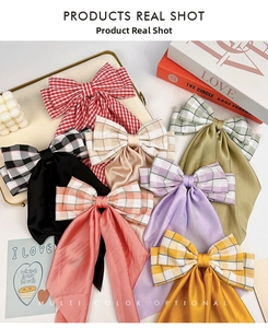 Detailed view of plaid fabric hair bows with long ribbons in multiple pastel colors