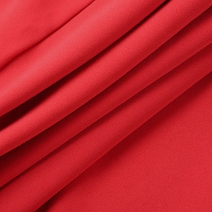 Dettaglio in primo piano del tessuto twill rosso con texture liscia e drappeggio