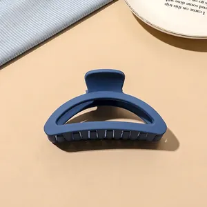 Macro detail of large matte Morandi blue D-shaped hair claw clip with strong teeth