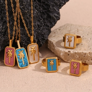 Detailed shot of gold palm tree pendants and rings with blue pink and white shells