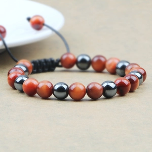 Macro shot of tiger eye beads and grey hematite stones on an adjustable braided bracelet
