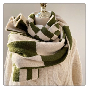 Detail of green and beige checkerboard cashmere-like scarf showing warm knit texture
