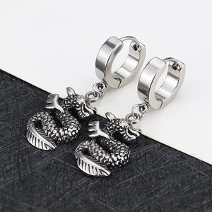 Detailed macro view of silver dragon pendant earrings with polished hoops and zircon eyes