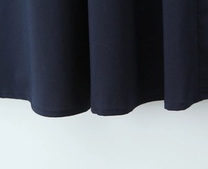 Vue détaillée de l'ourlet de robe bleu foncé avec couture précise et tissu lisse