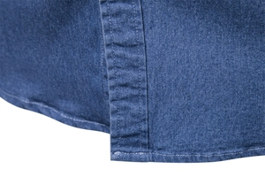 Close-up of double-stitched seams and fabric texture on a blue denim casual shirt
