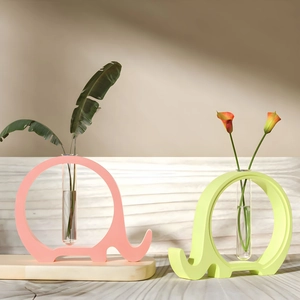 Detail view of elephant-shaped silicone vases in pink and green with glass test tubes