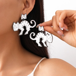 Detail of white acrylic cat drop earrings with black stripes on a female model