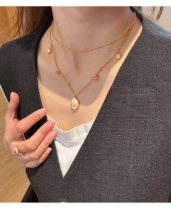 Gros plan d'un collier double couche plaqué or 18 carats avec nacre sur le cou