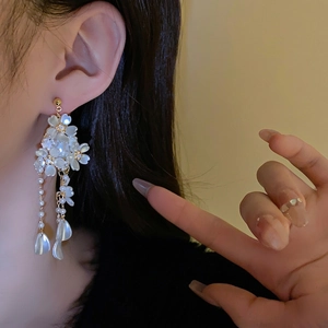 Elegant long tassel earrings with white petal flowers and pearls on golden metal studs