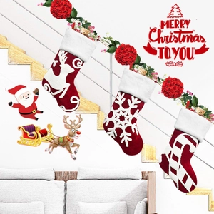 Detail of embroidered fleece Christmas stockings featuring reindeer and snowflake designs