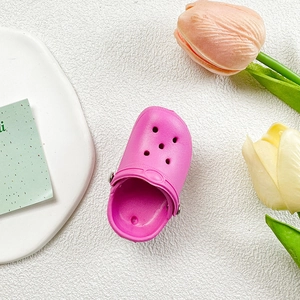 Close-up of pink mini slipper phone stand with vent holes and adjustable strap detail