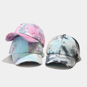 Detailed stack of distressed tie-dye baseball caps featuring torn vintage fabric textures