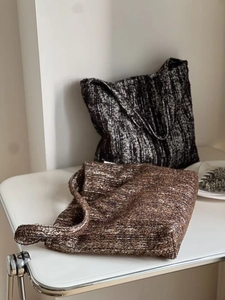 Detail of minimalist knitted tote bags in dark coffee and grey textured wool fabric