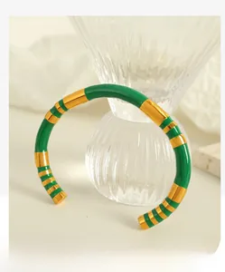 Detail of vintage gold plated cuff bracelet with vibrant emerald green enamel stripes