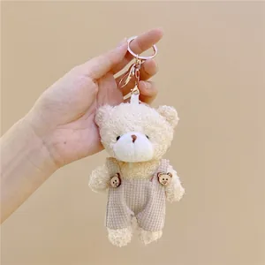 Llavero de osito de peluche con peto de pana y cierre de mosquetón dorado