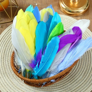 Close-up of colorful DIY goose feathers in a woven basket for wedding crafts