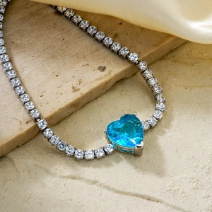 Elegant heart-shaped blue zircon tennis bracelet with white stones on a satin background