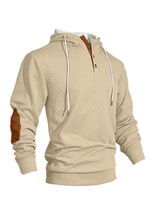 Détail du sweat à capuche gaufré avec coudières marron et texture du col à boutons
