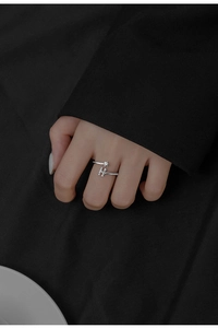 Close-up of S925 sterling silver H letter ring with a sparkling zircon on dark fabric
