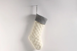 Detail of cable knit Christmas stocking in cream and gray with hanging loop
