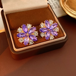 Dettaglio di orecchini vintage a fiore con cristalli marquise viola e placcati oro