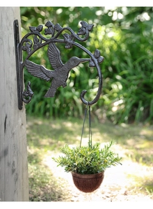 Detail eines gusseisernen Wandhakens mit Kolibri-Motiv für hängende Gartenpflanzen