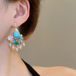 Detail of bohemian silver needle earrings with turquoise, pearl tassels and crystals