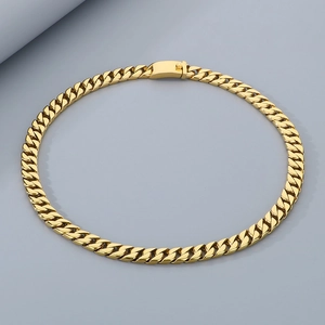 Macro detail of 12mm gold stainless steel Cuban link chain with secure box clasp
