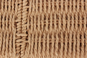 Macro shot of natural straw woven texture and detailed fiber pattern on a casual bag