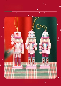Detail of three pink nutcracker ornaments with sweet cake hats and gold hanging strings